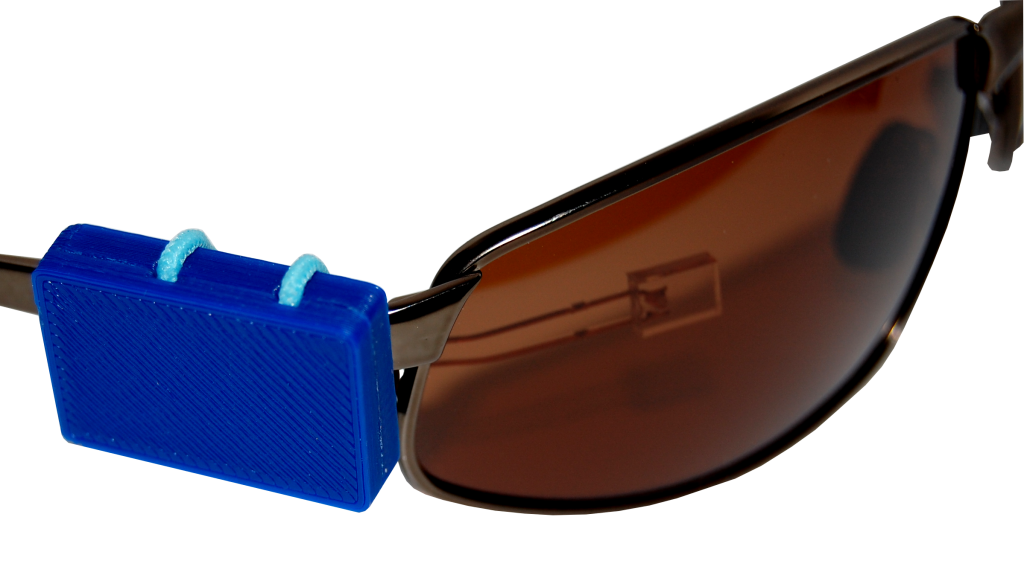 Прибор DreamTrainer для автоматических напоминаний о проверке реальности (для получения осознанных сновидений), в рабочем положении, закреплен на очках, вид с внешней стороны очков, с прилегающим к стеклу светодиодом.